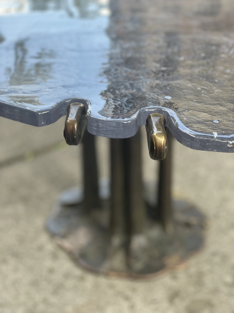 Textured glass edge held by worked metal.